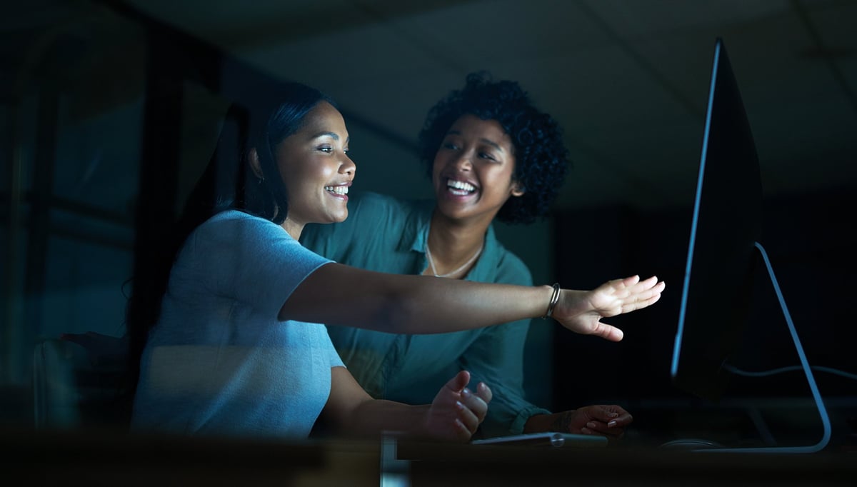 Two people working together on a computer on a website project